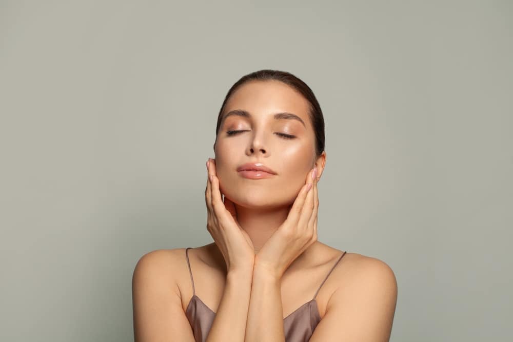 Attractive woman with healthy skin relaxing with closed eyes, concept of spa wellness, beauty, and skincare.